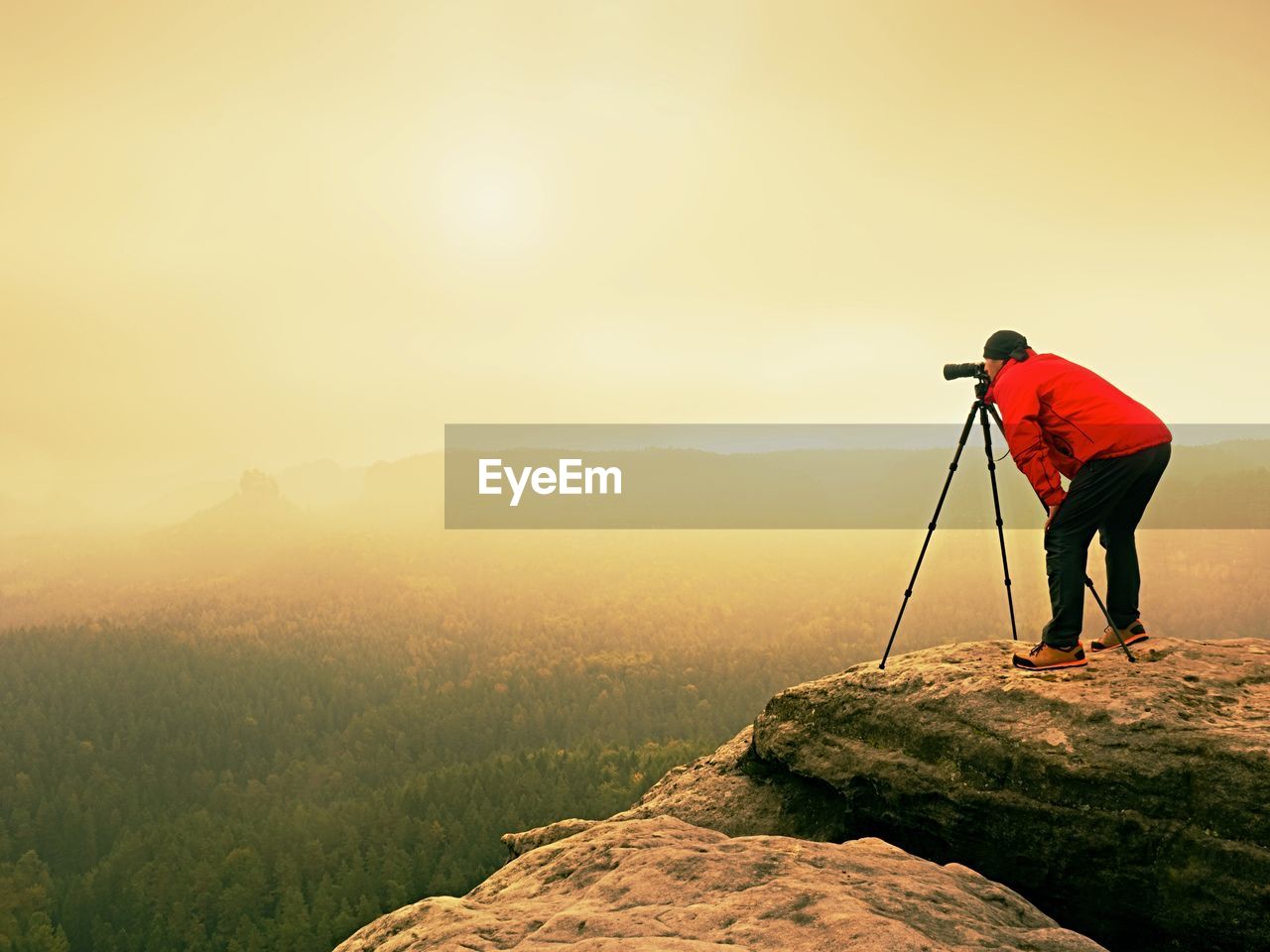 Professional photographer work on mountain peak. nature photographer takes photos with mirror camera