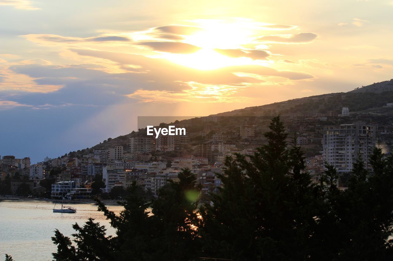 PANORAMIC SHOT OF BUILDINGS AGAINST SKY DURING SUNSET