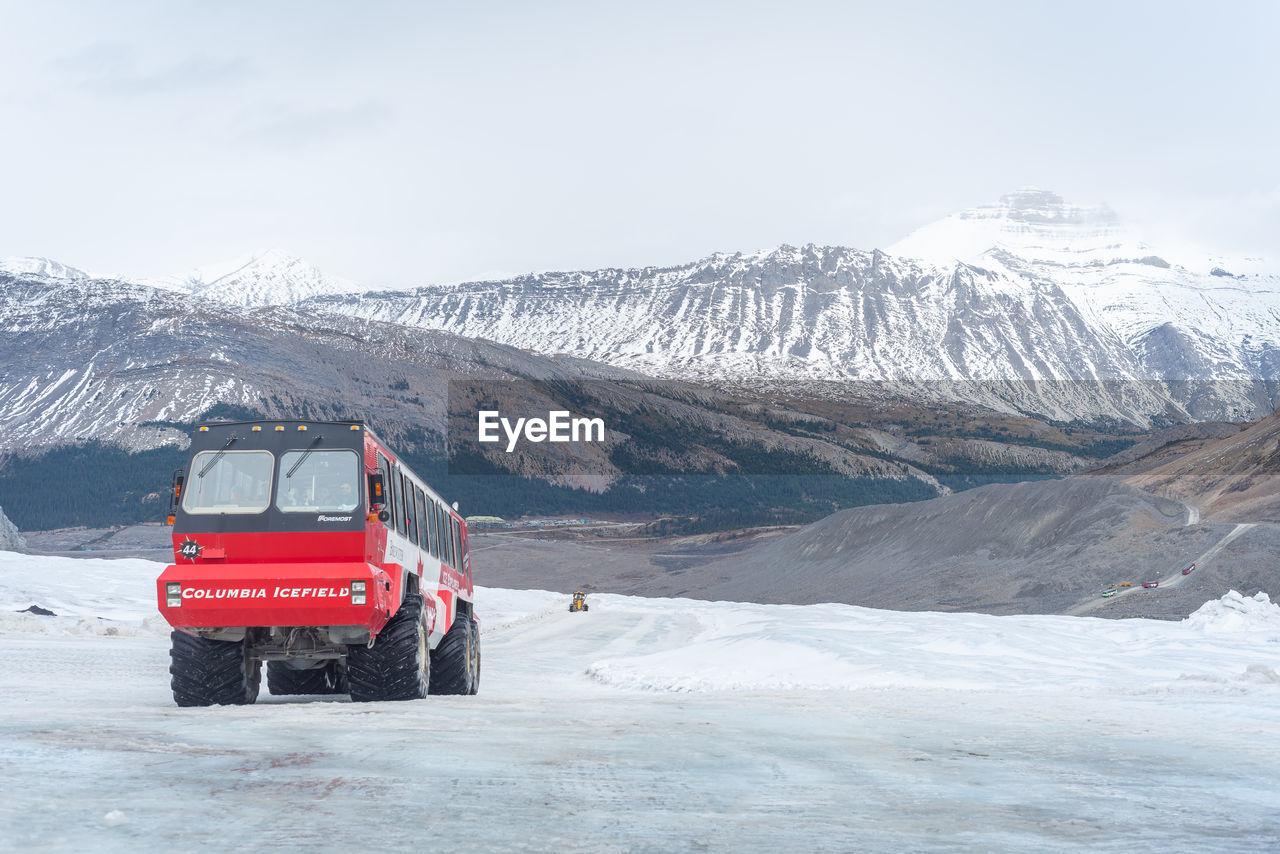 TRACTOR ON SNOWCAPPED MOUNTAIN AGAINST SKY