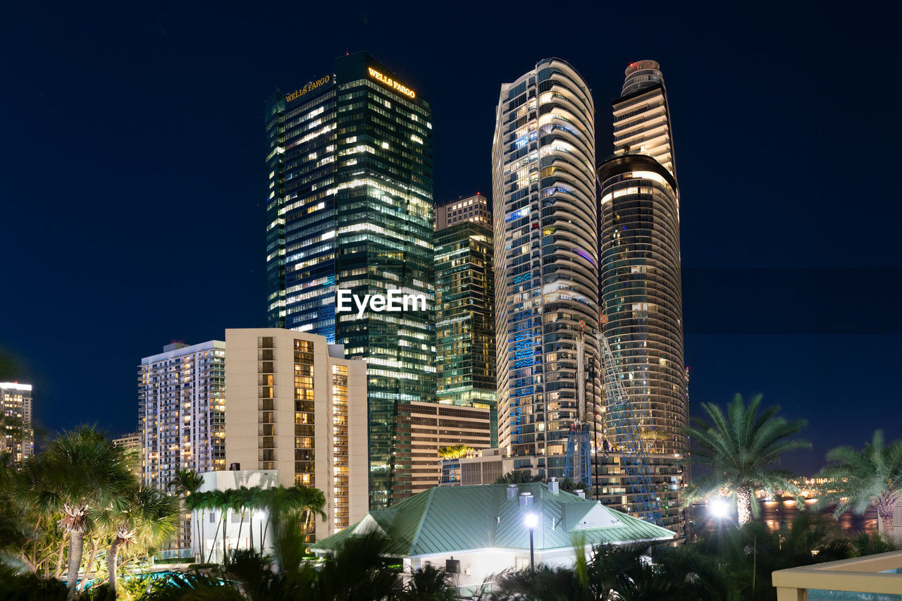 architecture, city, building exterior, built structure, office building exterior, skyscraper, night, building, illuminated, metropolitan area, metropolis, landmark, cityscape, residential district, sky, travel destinations, skyline, office, urban skyline, tower block, landscape, nature, downtown, tree, condominium, downtown district, no people, city life, urban area, plant, travel, hotel, outdoors, street, business, luxury hotel, tourism, tower