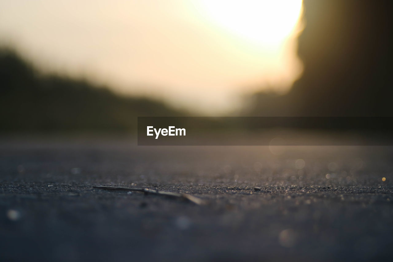 Surface level of road against sky during sunset