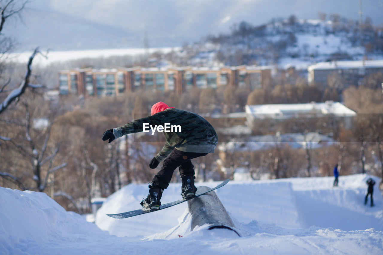 Man snowboarding on land against sky