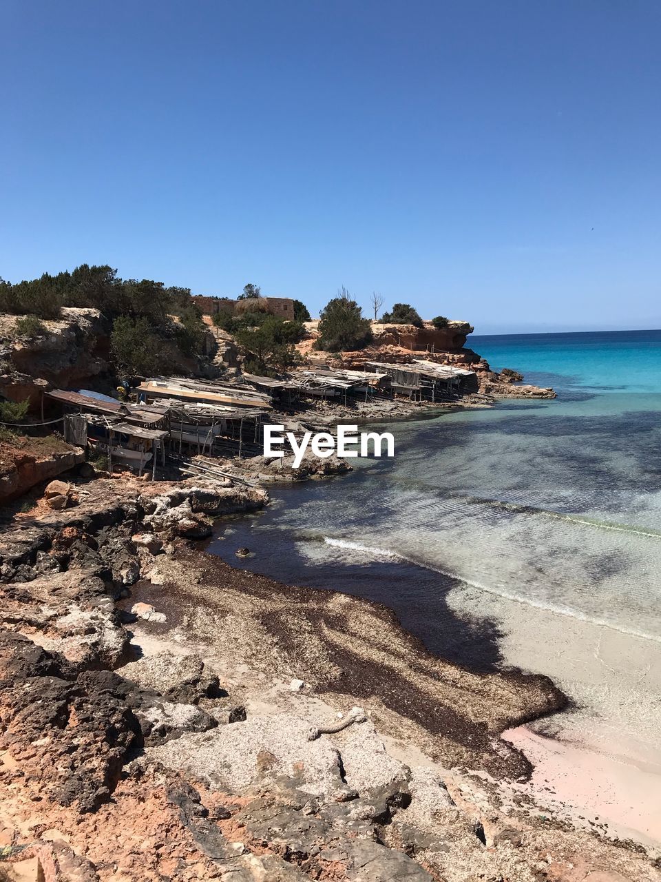 Scenic view of beach against clear blue sky