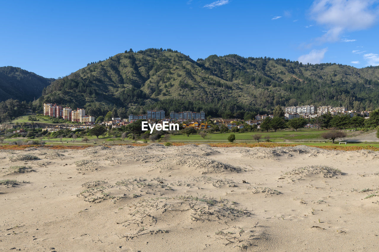 land, sky, mountain, nature, landscape, environment, sea, scenics - nature, architecture, tree, plant, sand, beach, building, travel destinations, travel, blue, no people, built structure, water, outdoors, building exterior, beauty in nature, day, natural environment, plateau, mountain range, body of water, coast, tourism, house, village, sunny