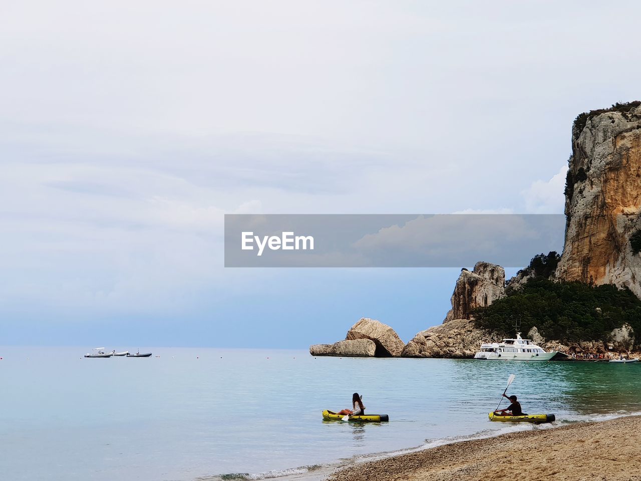 PANORAMIC VIEW OF PEOPLE ON SEA AGAINST SKY