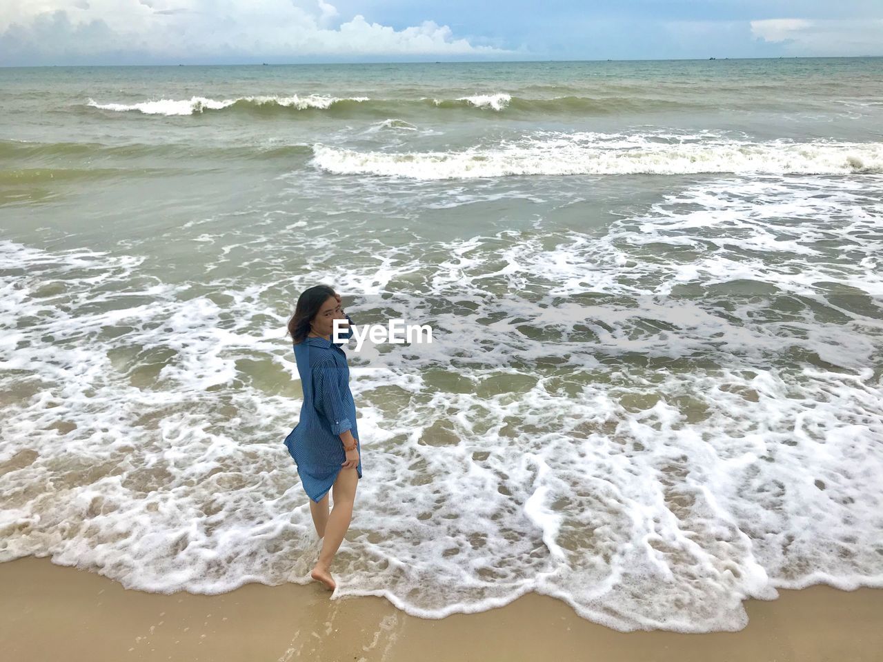 FULL LENGTH OF MAN STANDING ON SHORE AT BEACH