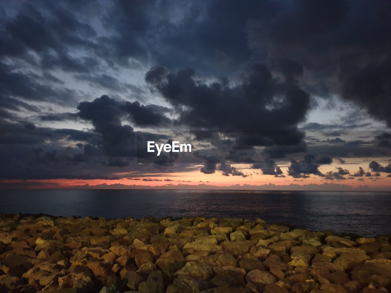 SCENIC VIEW OF SEA AGAINST DRAMATIC SKY DURING SUNSET