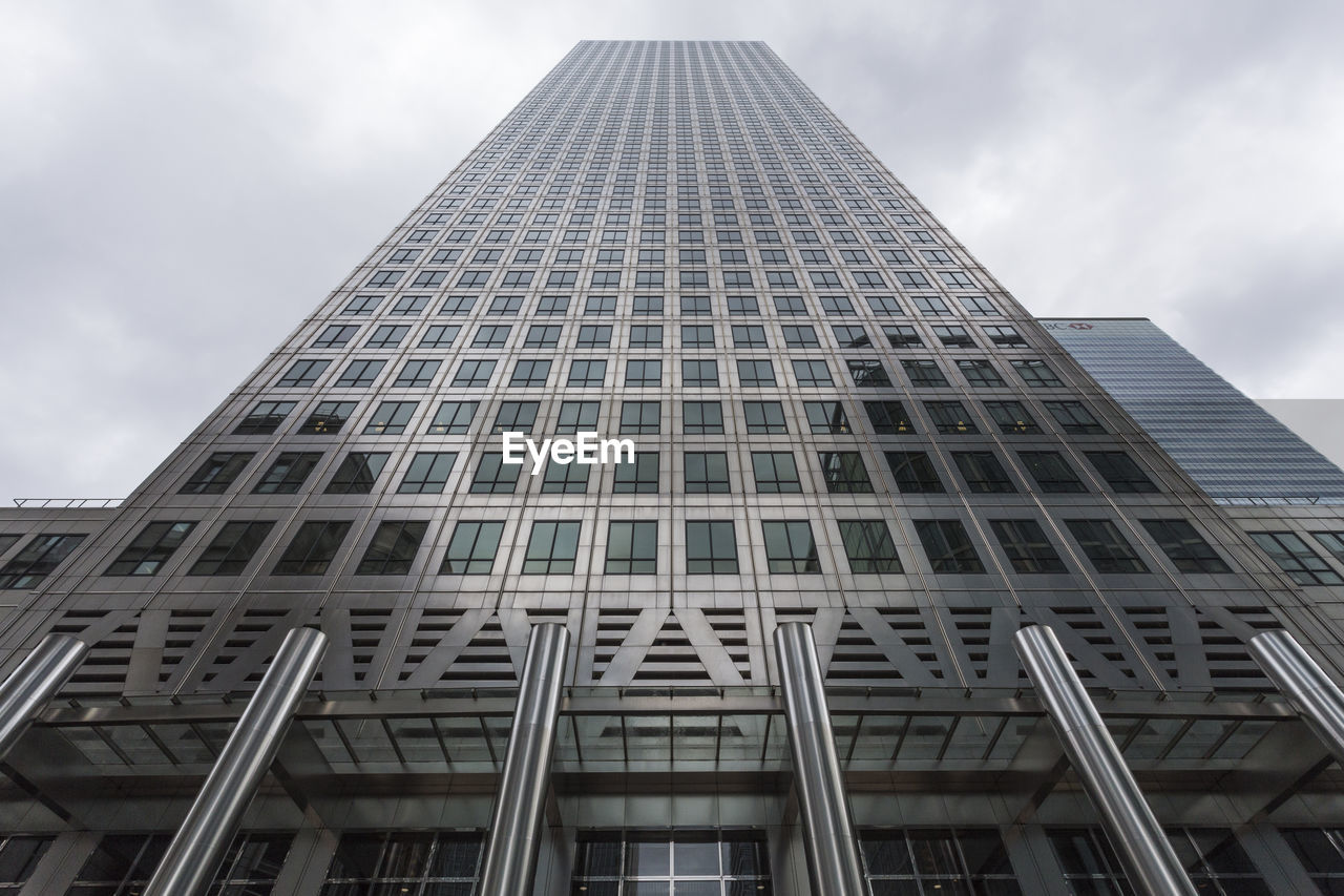 LOW ANGLE VIEW OF SKYSCRAPER AGAINST CLOUDY SKY