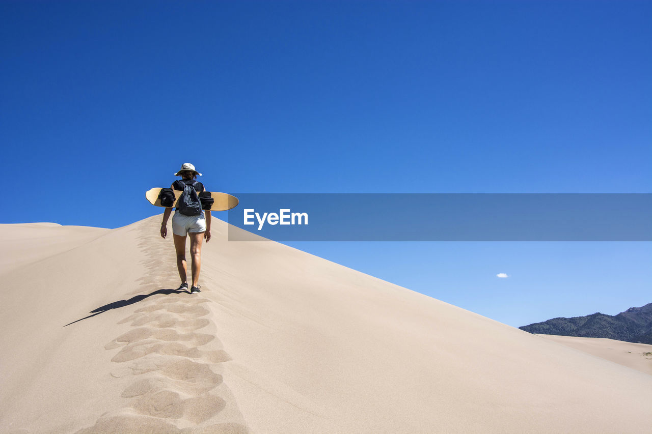 FULL LENGTH OF MAN ON DESERT AGAINST SKY