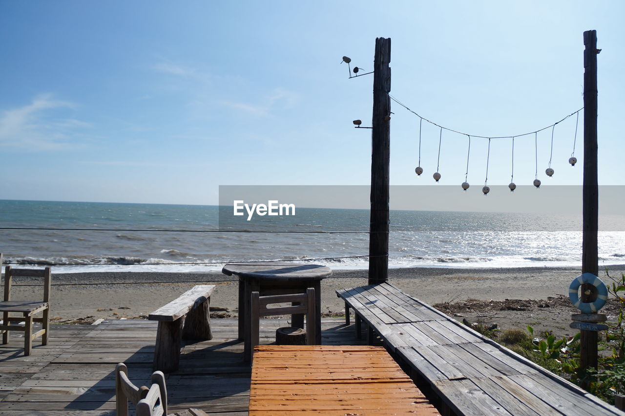 DECK CHAIRS AND TABLE AGAINST SEA