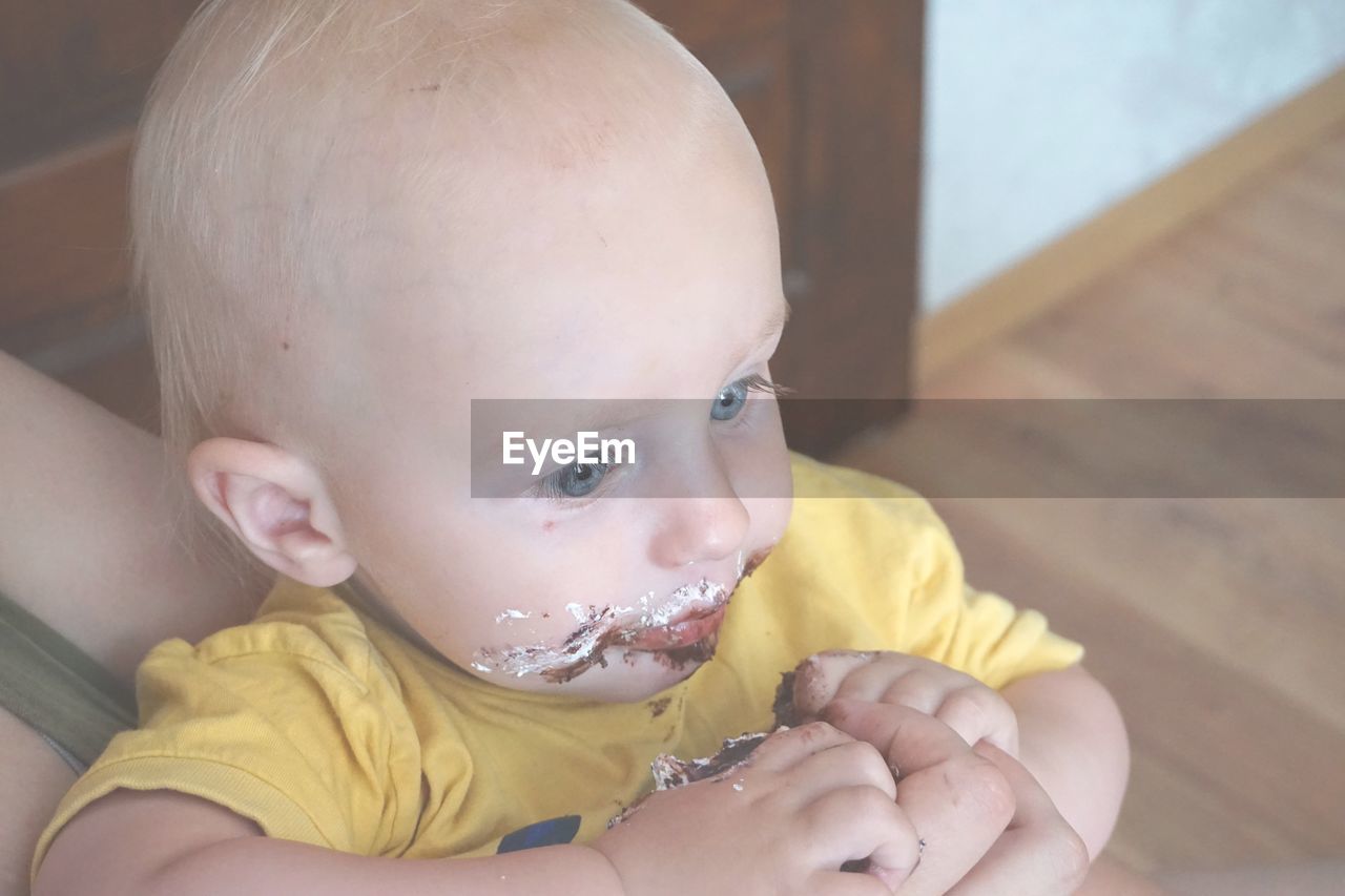 Close-up of cute baby boy eating cake