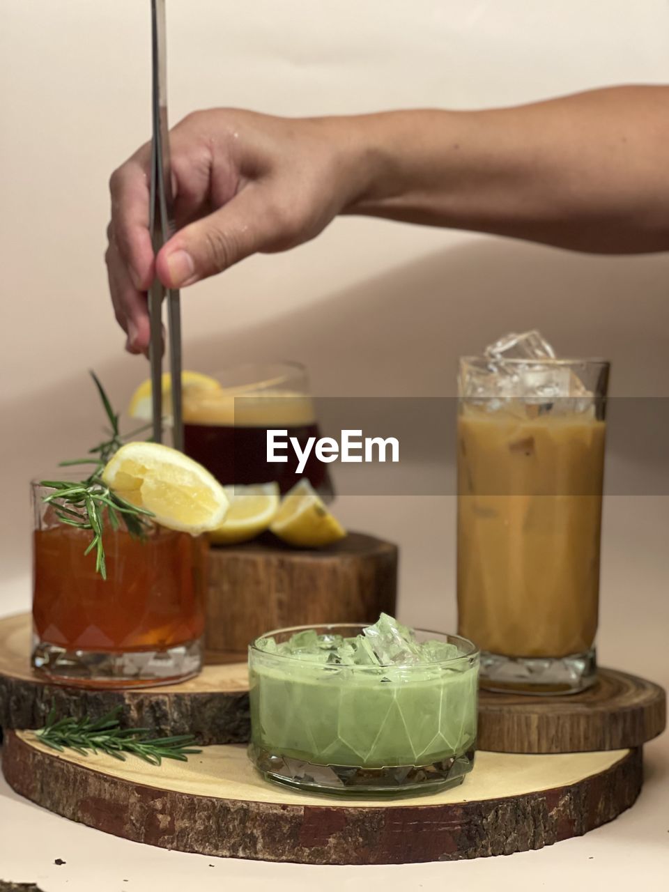 CLOSE-UP OF HAND HOLDING GLASS OF JUICE