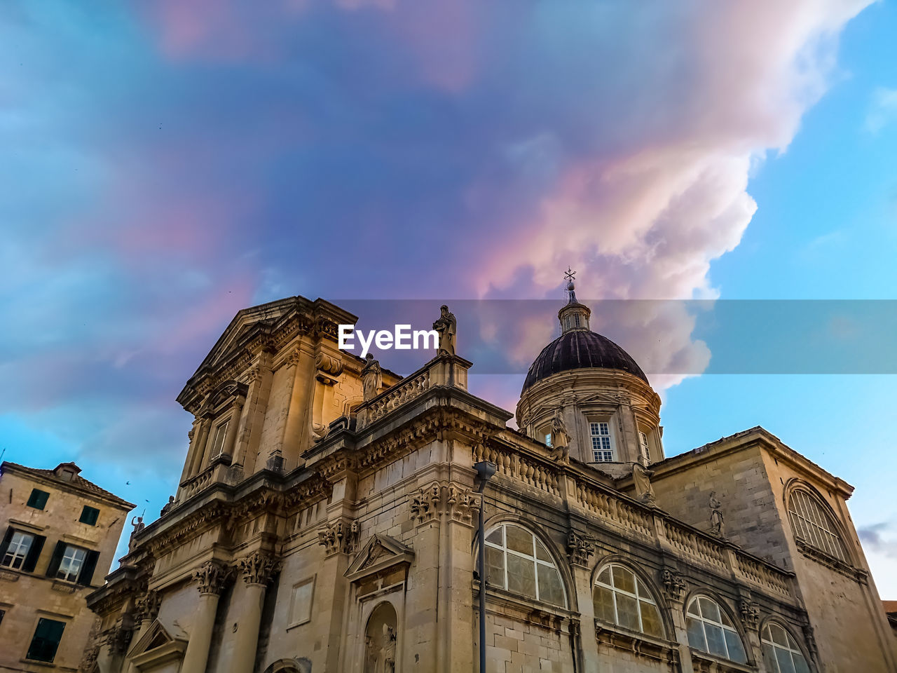 LOW ANGLE VIEW OF BUILDING AGAINST CLOUDY SKY