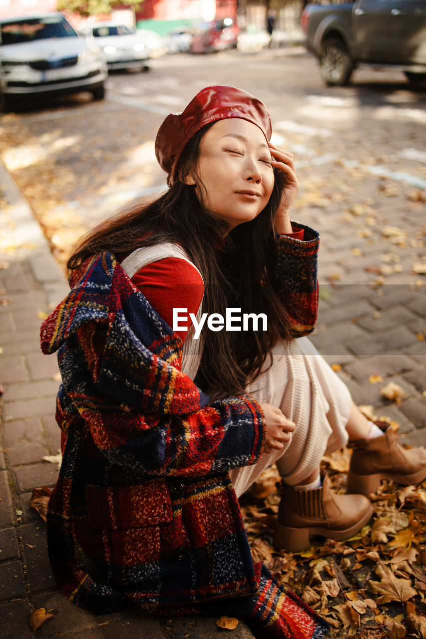 portrait of young woman looking away while standing outdoors