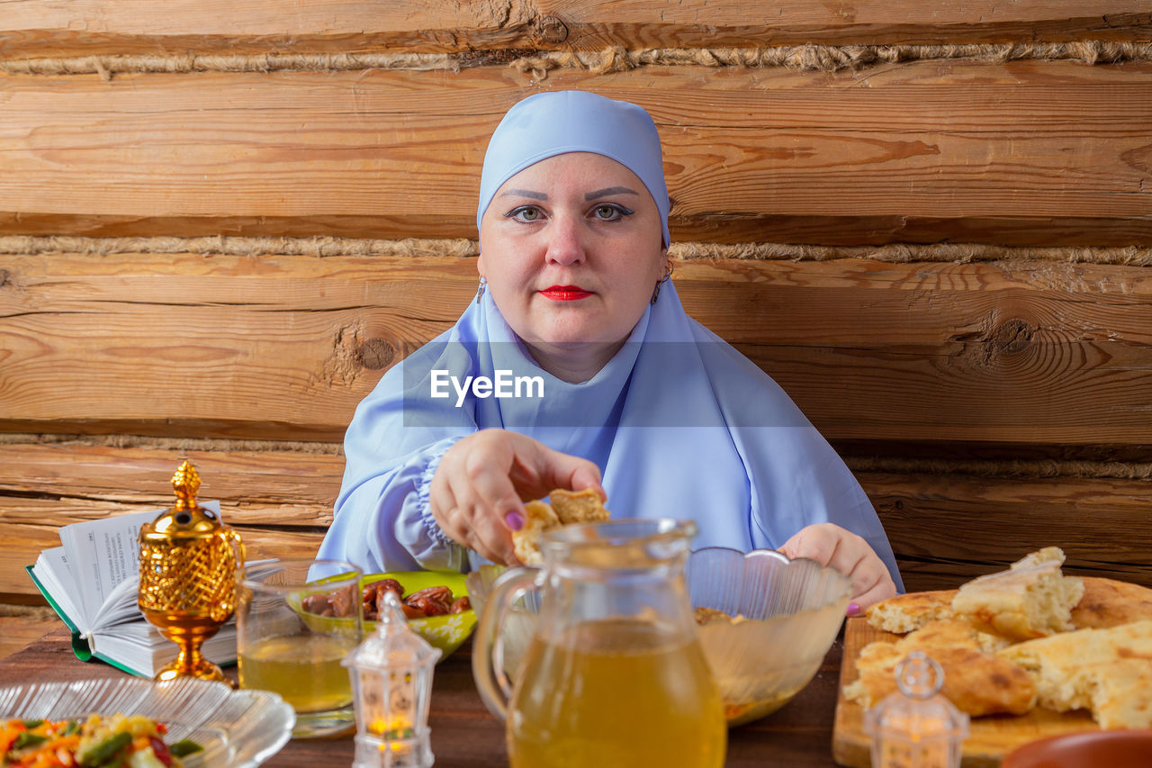 portrait of young woman with food on table