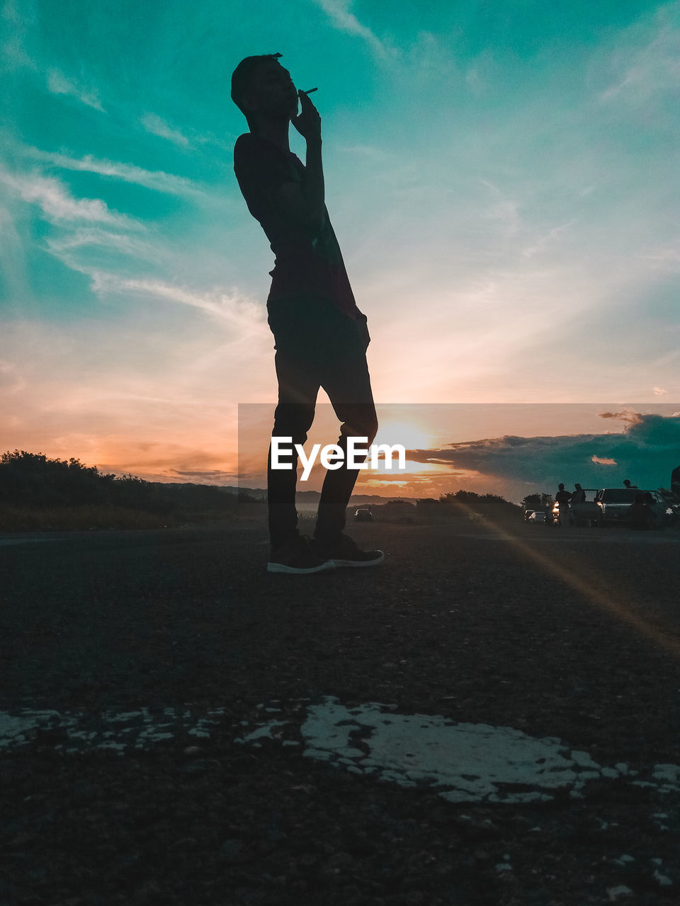 Silhouette man standing on field against sky during sunset