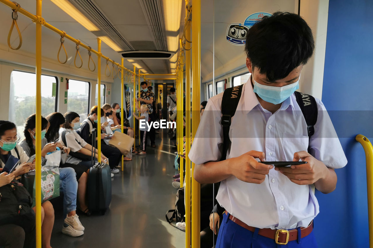 REAR VIEW OF PEOPLE STANDING IN BUS