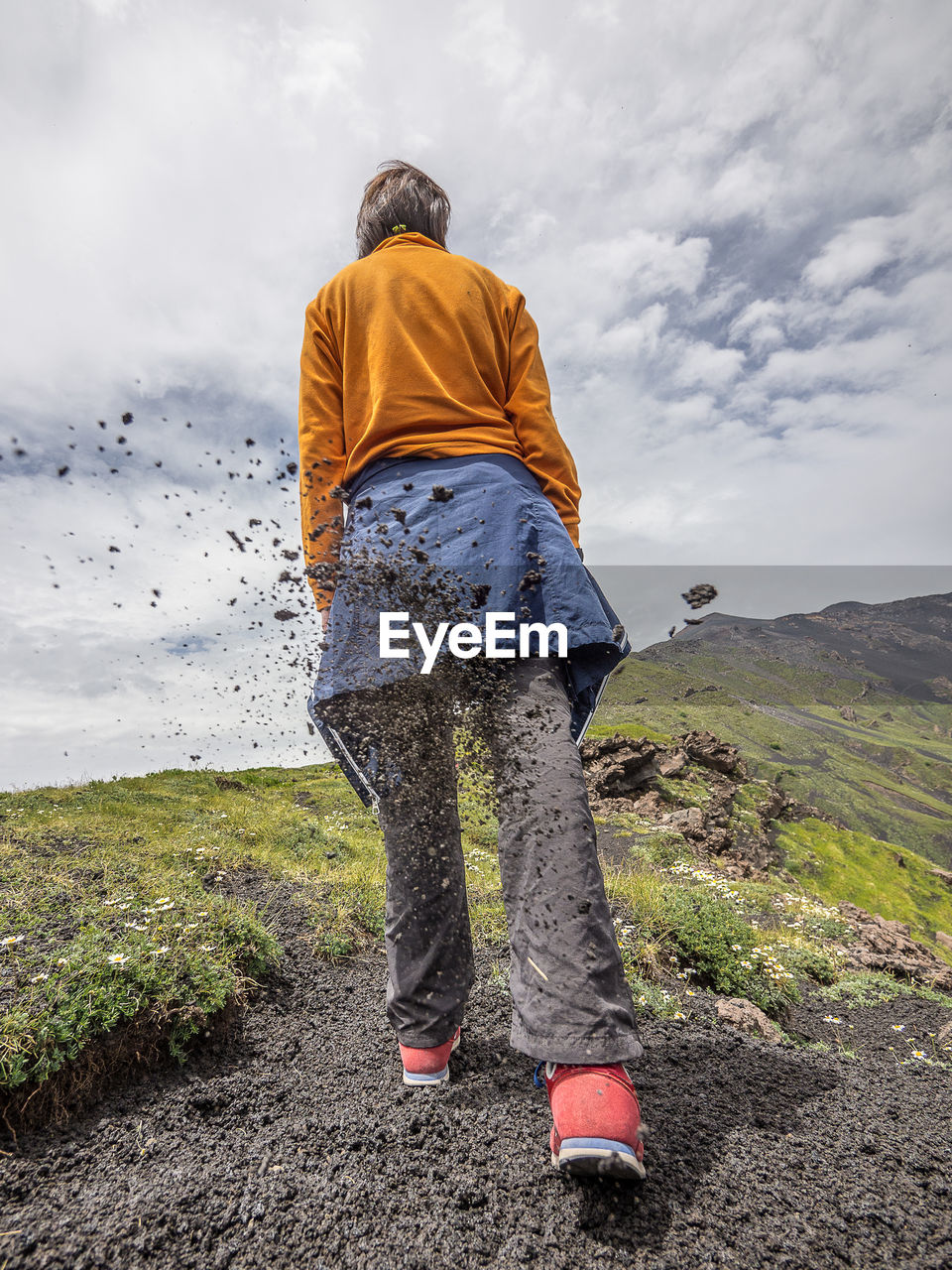 Rear view of woman standing on land against sky