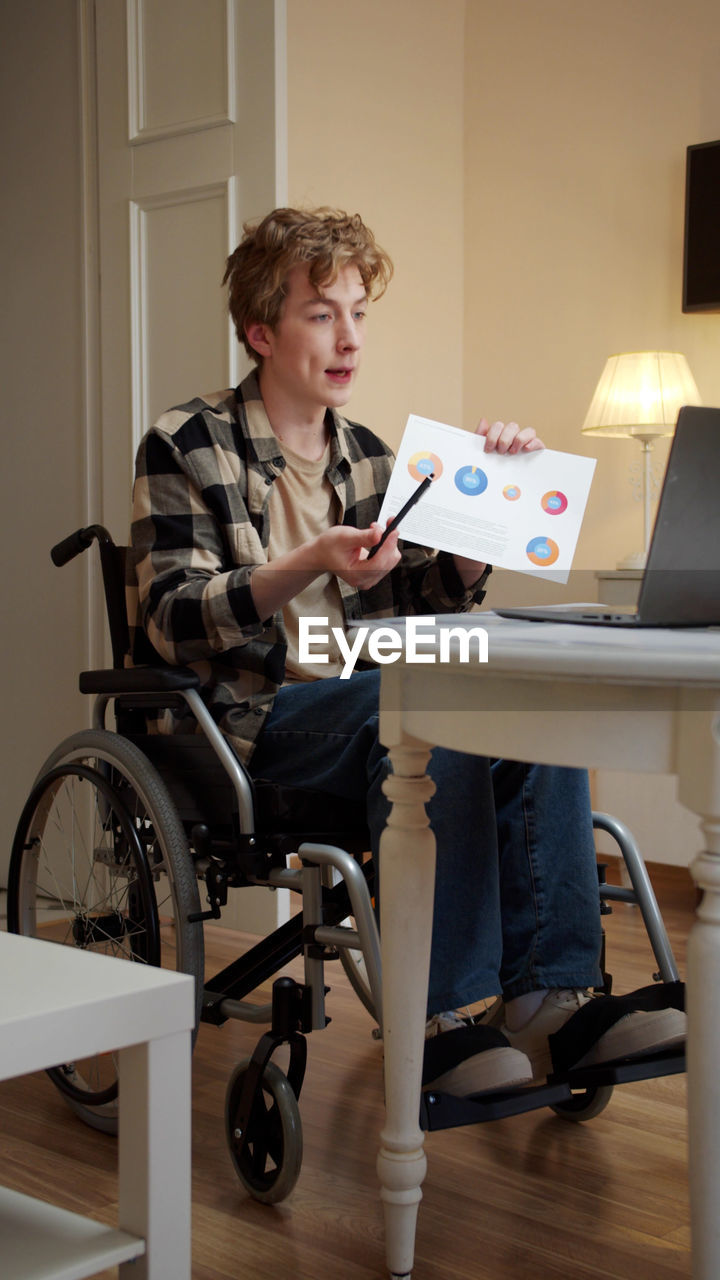 Young disabled man talking on video conference