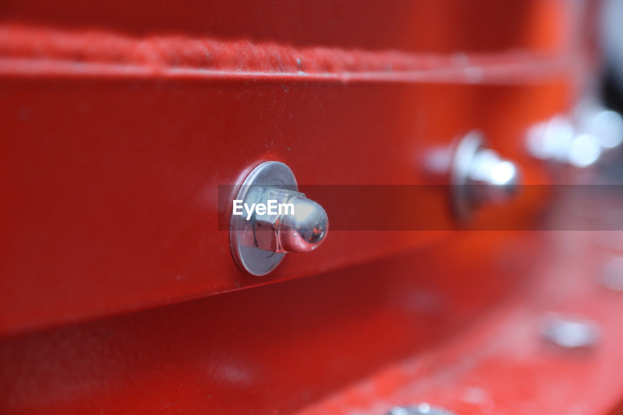 Close-up of nut and bolt on red metal