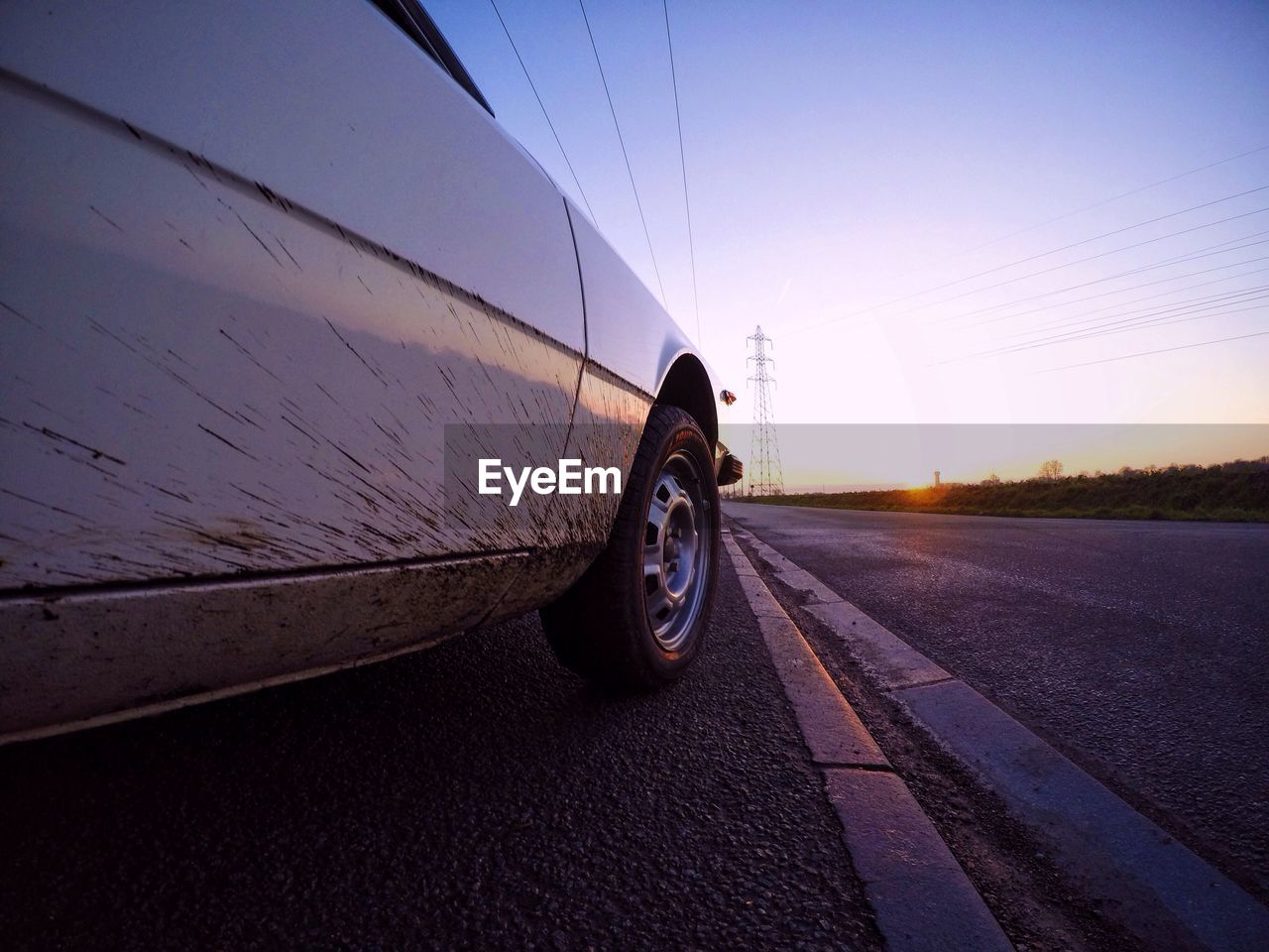 Car on street against sky during sunset