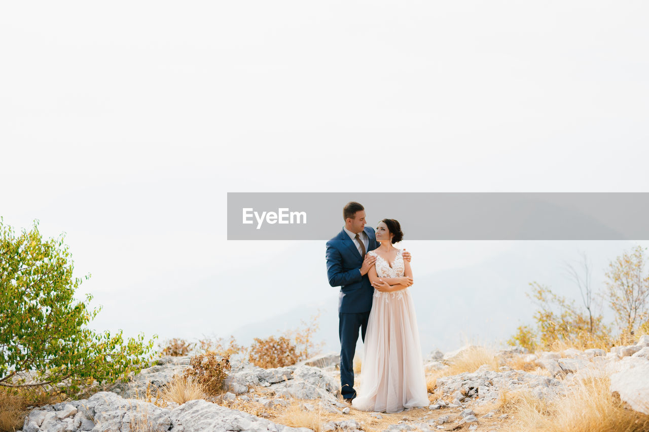 Front view of couple standing on rock