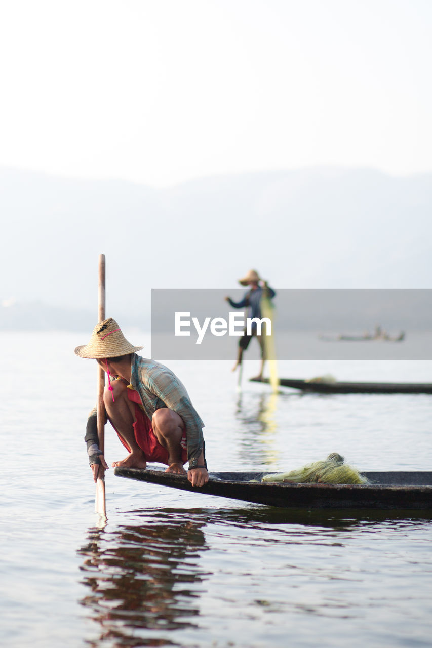 MAN AND WOMAN IN BOAT ON SEA