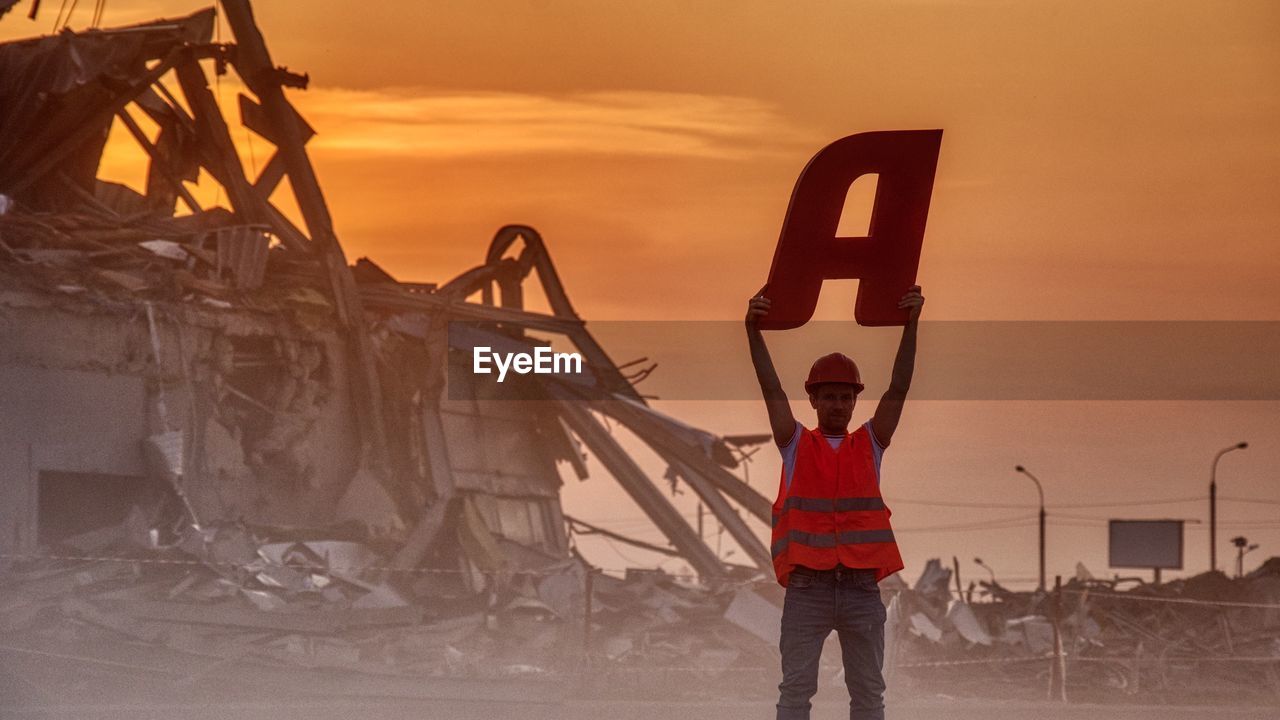 Man with a on the background of a destroyed building