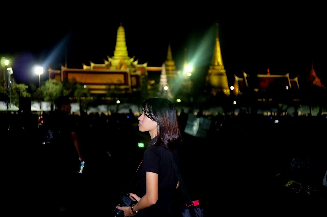 PEOPLE AT ILLUMINATED TOWN SQUARE AGAINST SKY