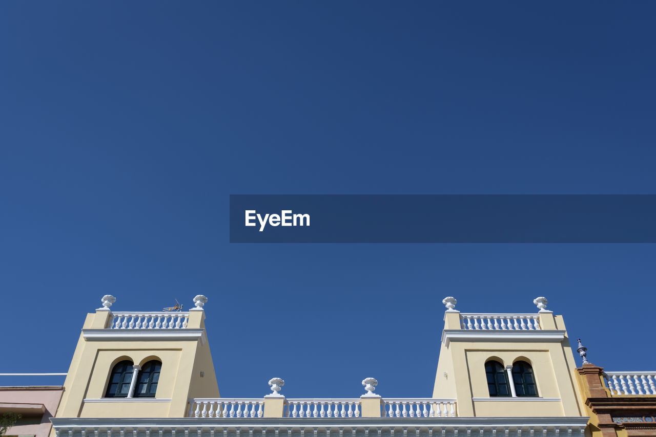 LOW ANGLE VIEW OF BUILDINGS AGAINST BLUE SKY