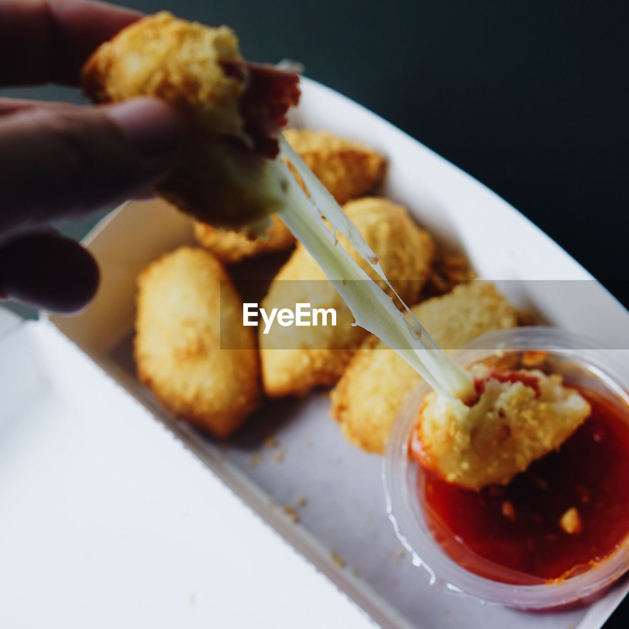 Cropped image of person holding cheese ball