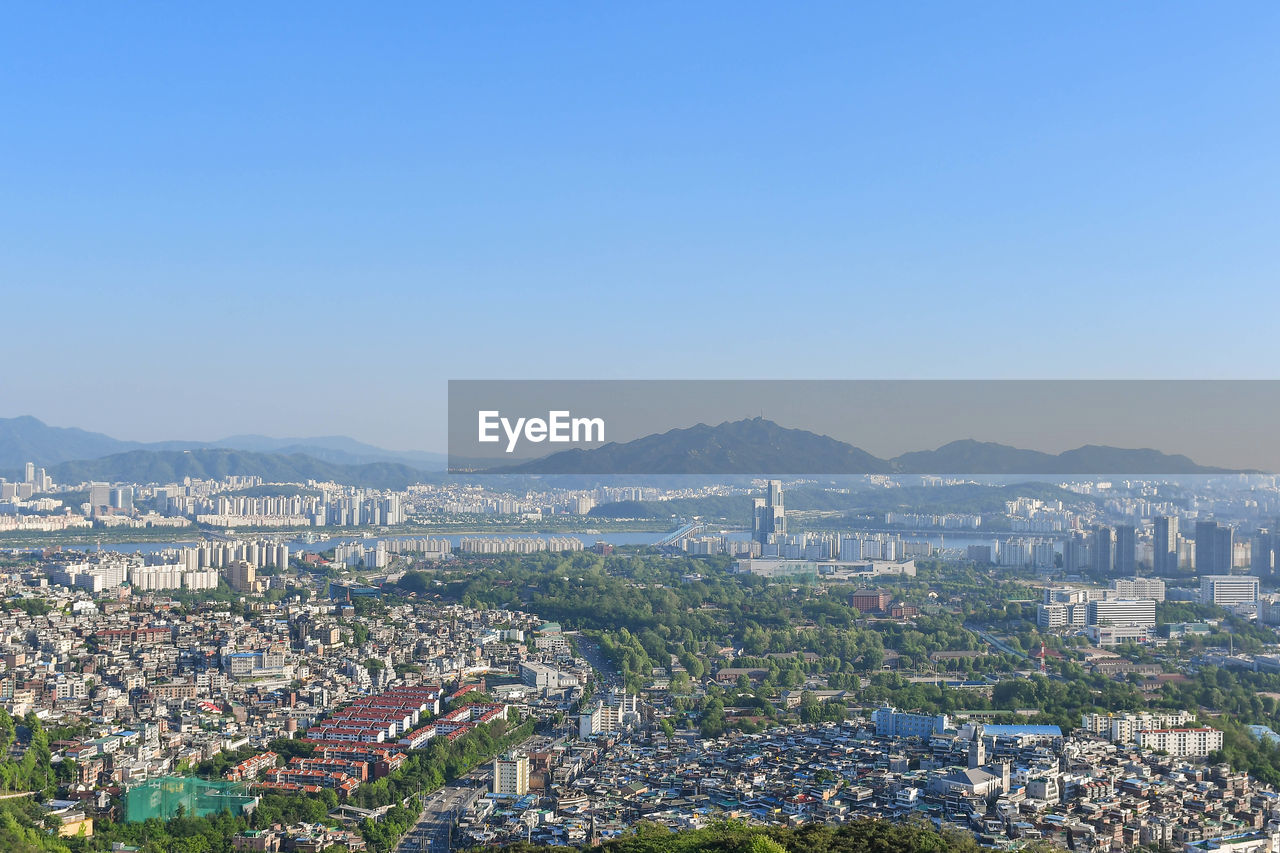 High angle view of cityscape against clear blue sky