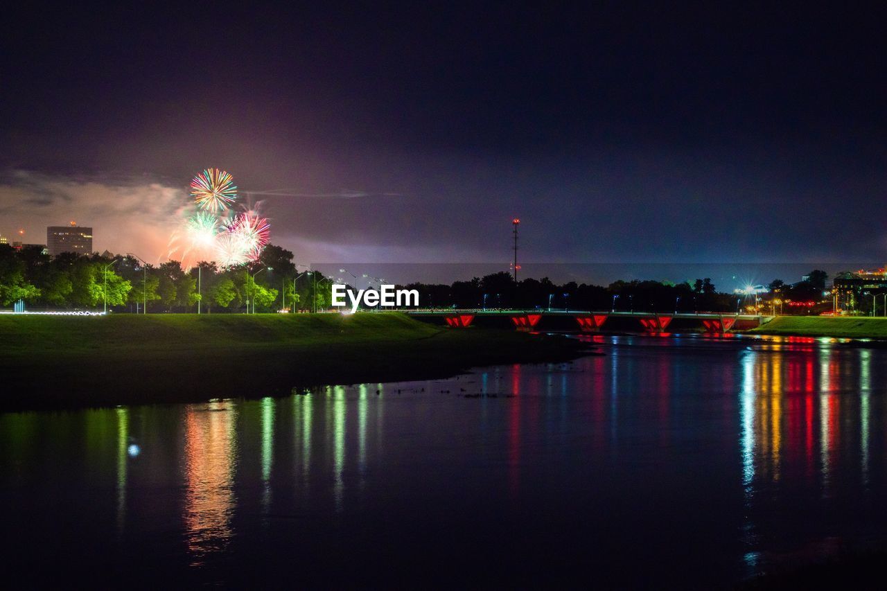 VIEW OF FIREWORK DISPLAY OVER RIVER IN CITY