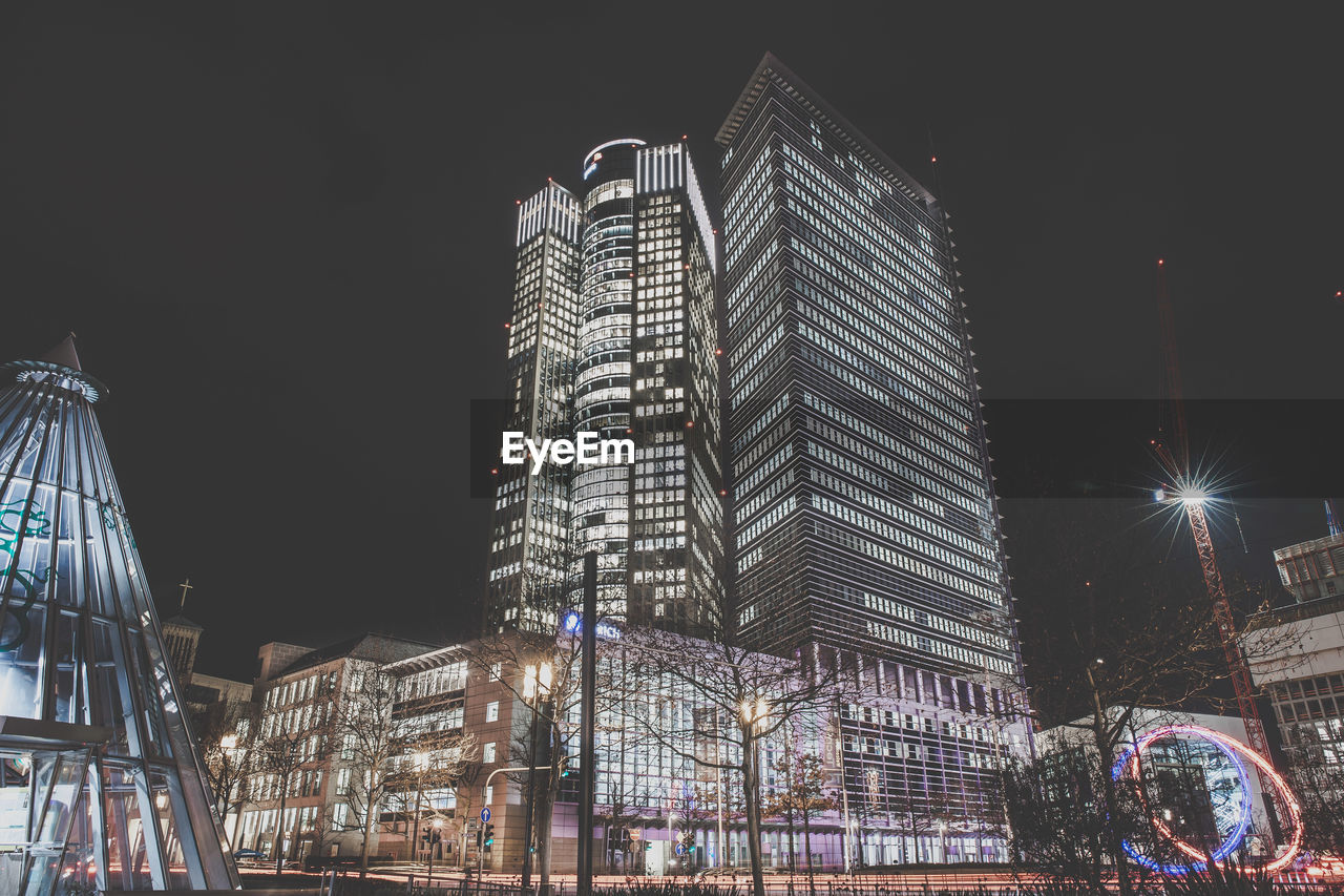 Low angle view of illuminated buildings against sky at night