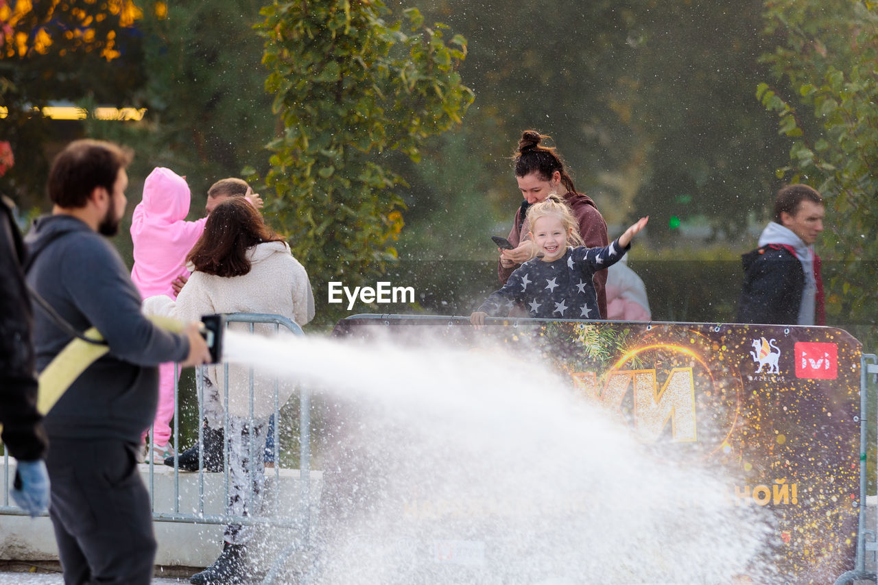 group of people, water, men, motion, adult, nature, splashing, fun, women, enjoyment, spraying, emotion, day, female, leisure activity, outdoors, togetherness, child, happiness, lifestyles, childhood, group, medium group of people, young adult, person, sports, tree, friendship, positive emotion, vehicle