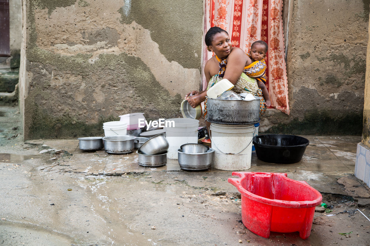 Woman with children washing utensils at home