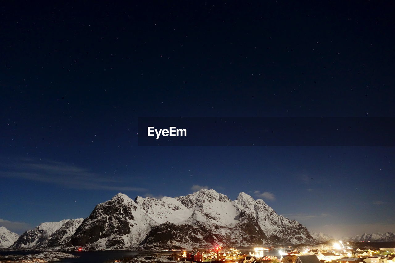 Scenic view of snowcapped mountains against sky at night