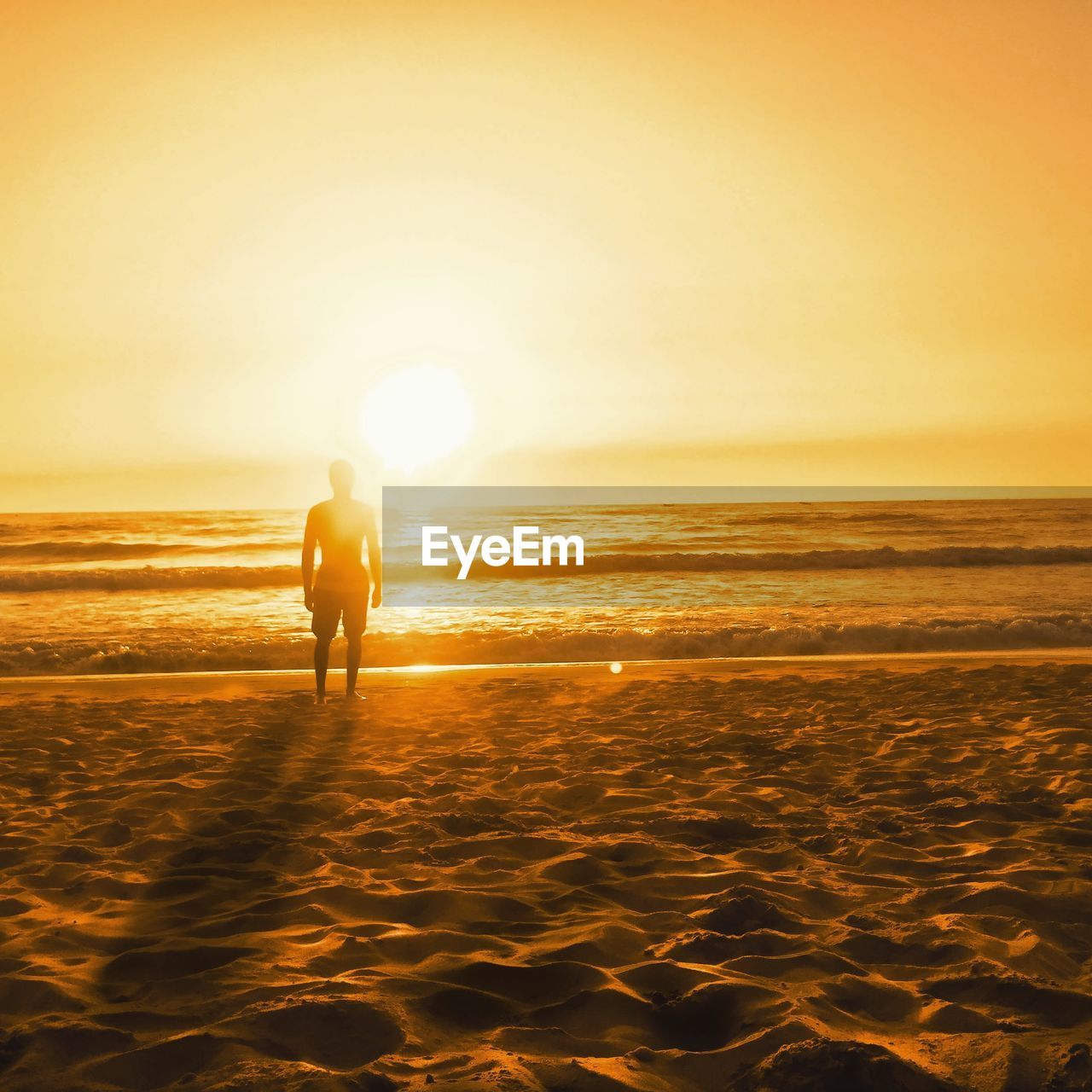 FULL LENGTH OF MAN ON BEACH DURING SUNSET