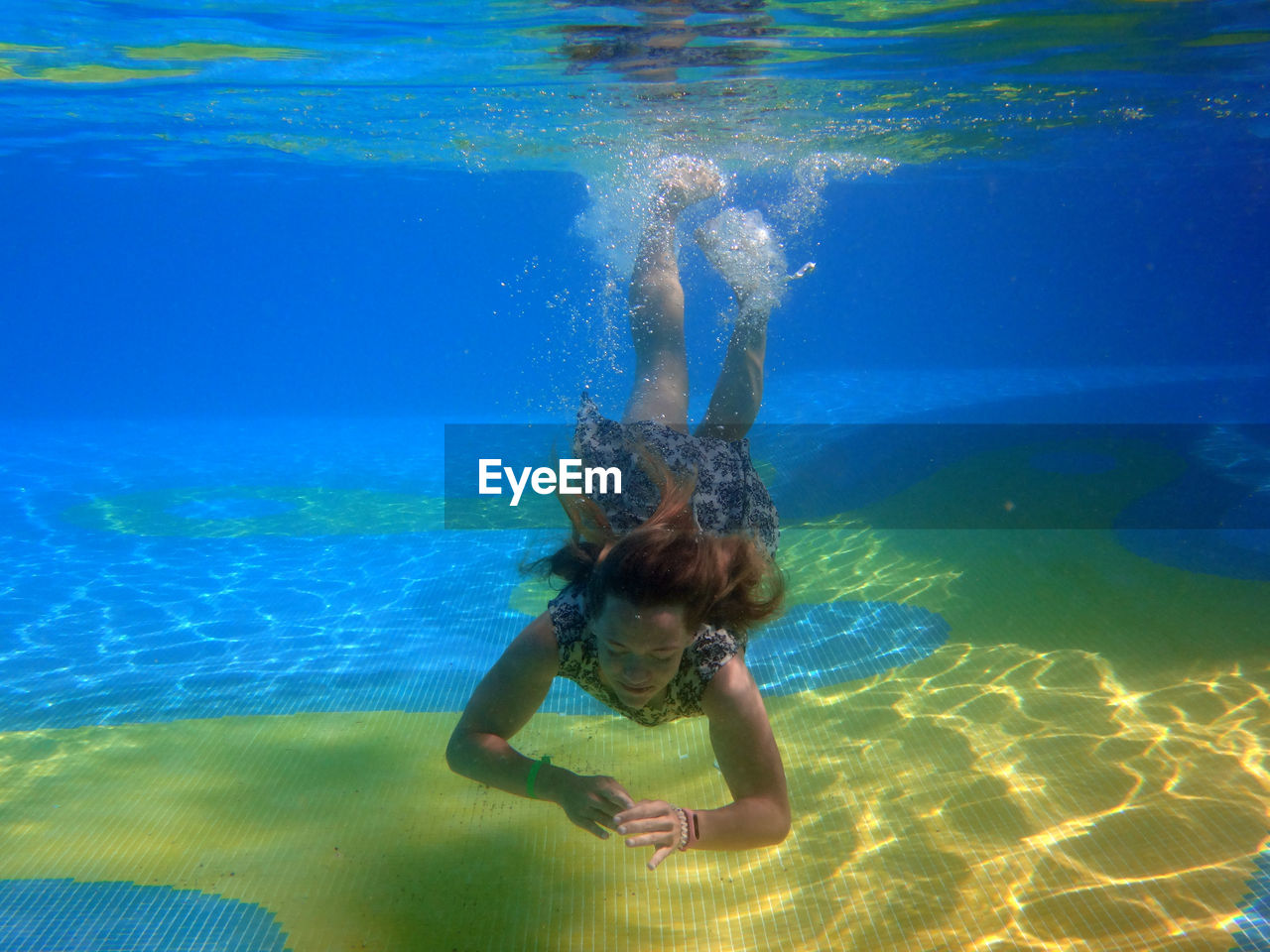 Full length of young woman swimming in pool