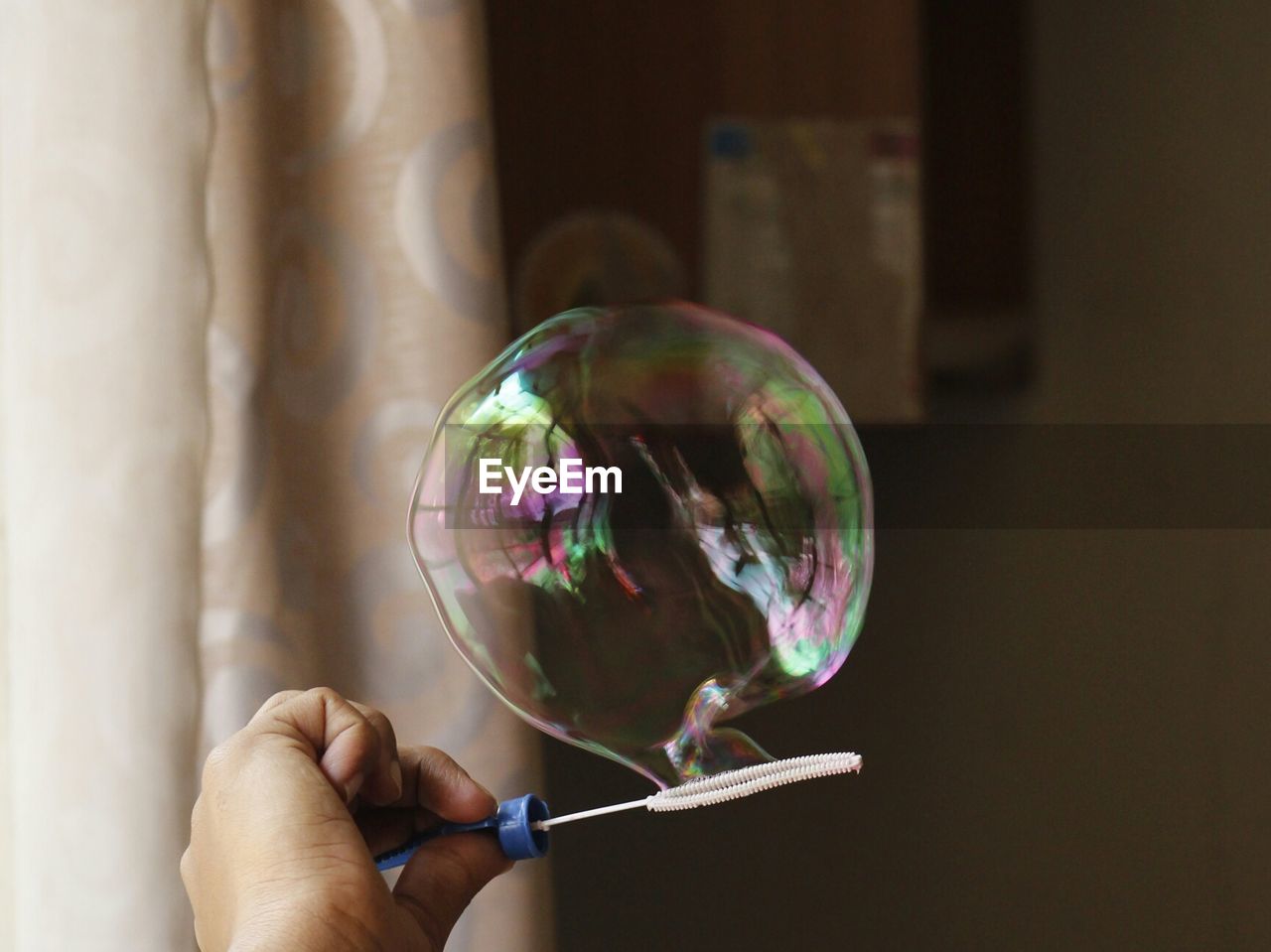 Cropped image of hand holding bubble