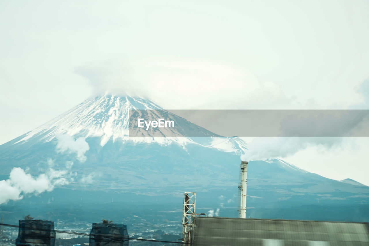 mountain, volcano, snow, cold temperature, winter, beauty in nature, sky, snowcapped mountain, landscape, scenics - nature, environment, nature, stratovolcano, travel destinations, smoke, fog, cloud, no people, mountain peak, travel, architecture, outdoors, day, built structure, geology, volcanic landscape, non-urban scene, land, tourism, building exterior, tranquil scene, tranquility, transportation