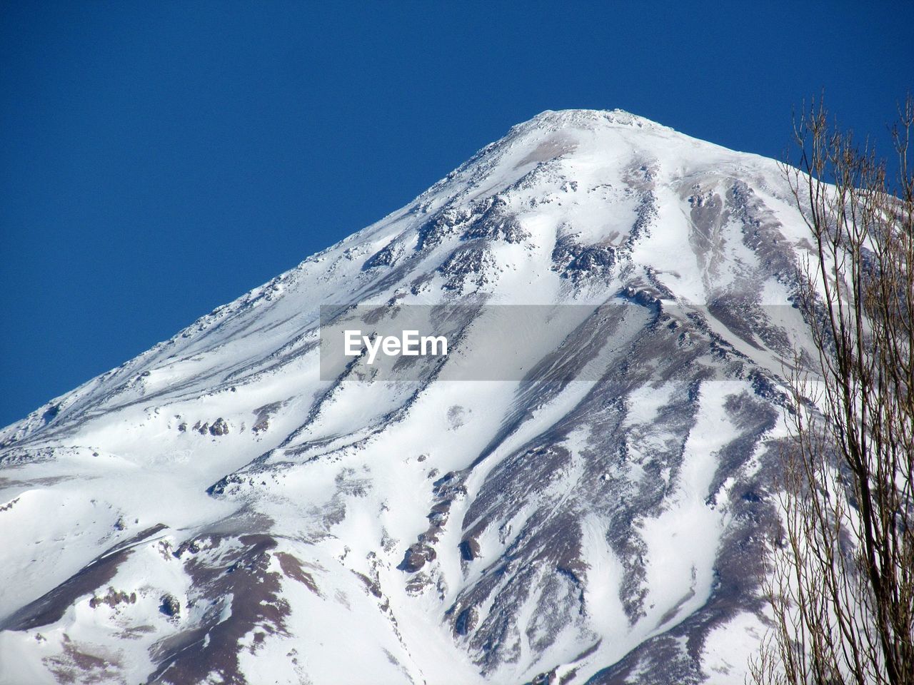 Scenic view of snowcapped mountains against blue sky