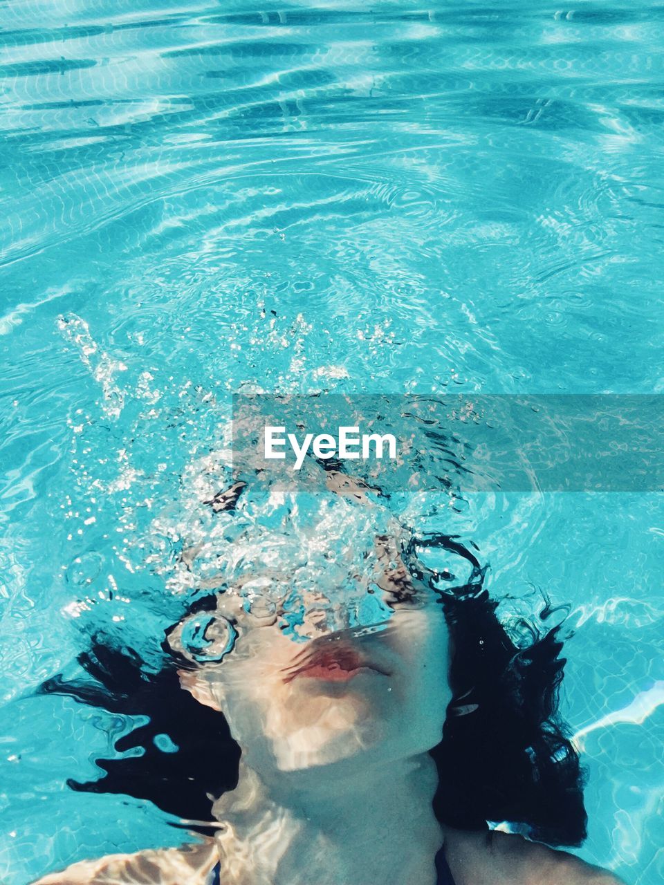 High angle view of young woman swimming in water