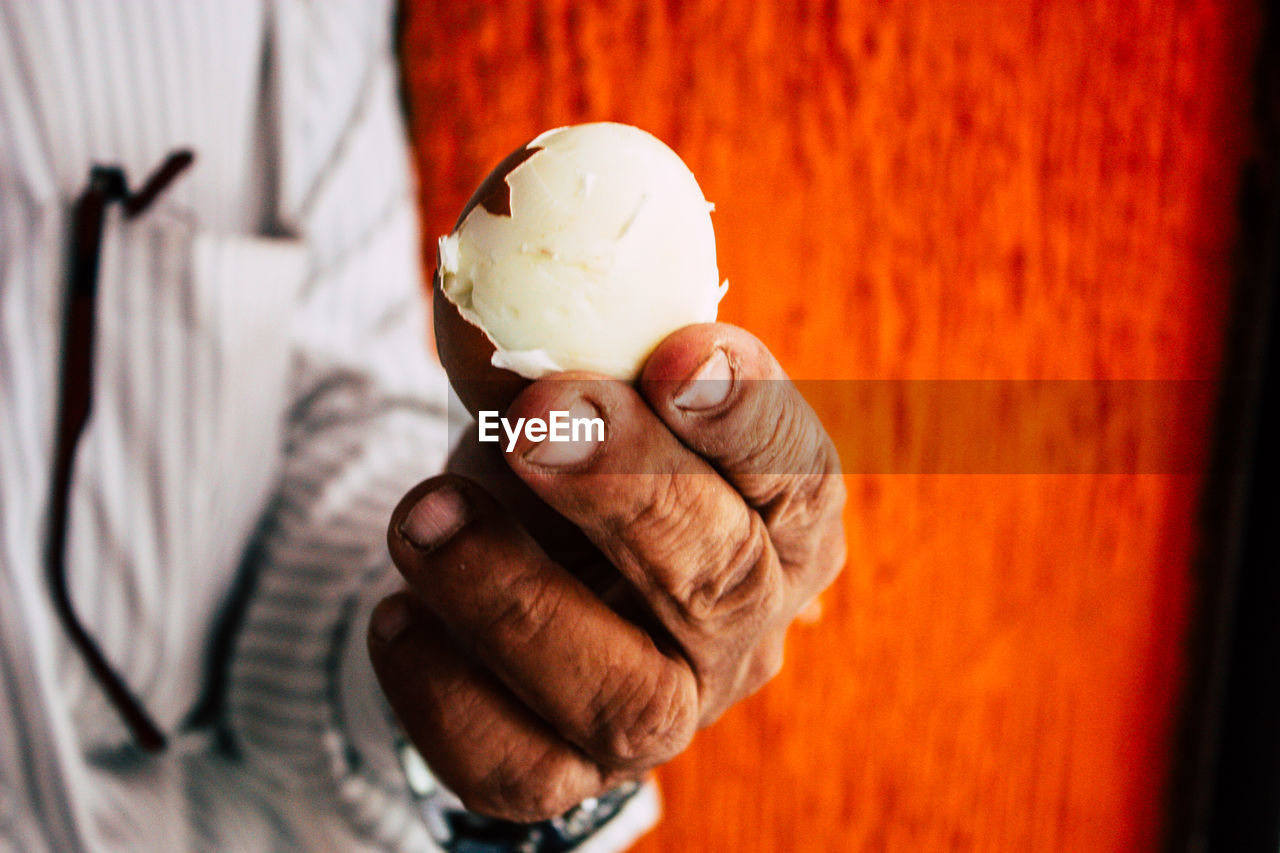 CLOSE-UP OF HUMAN HAND HOLDING ICE CREAM