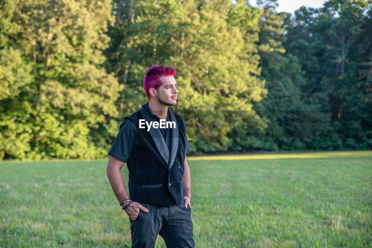 Man with pink hair standing outdoors