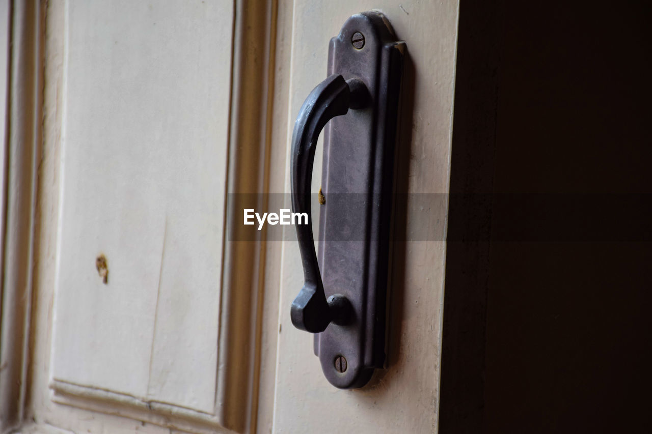 CLOSE-UP OF DOOR HANDLE ON WOODEN ENTRANCE