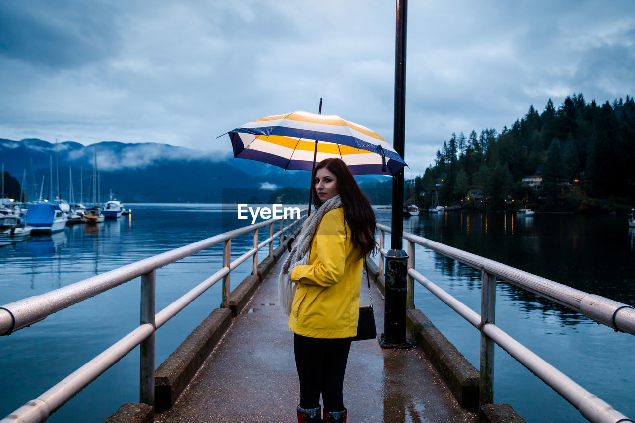 Woman standing on pier at lake