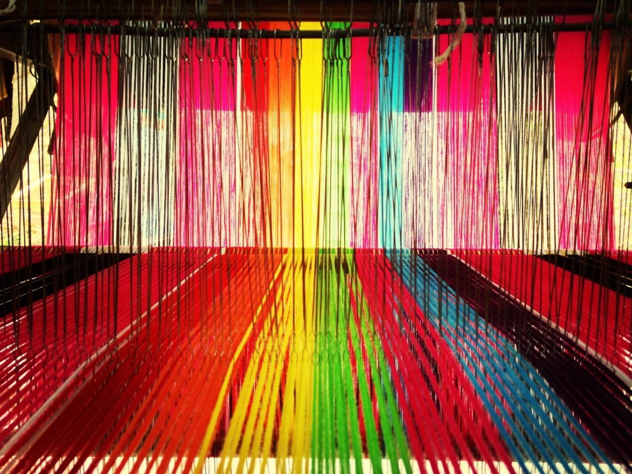Multi colored threads hanging on machine