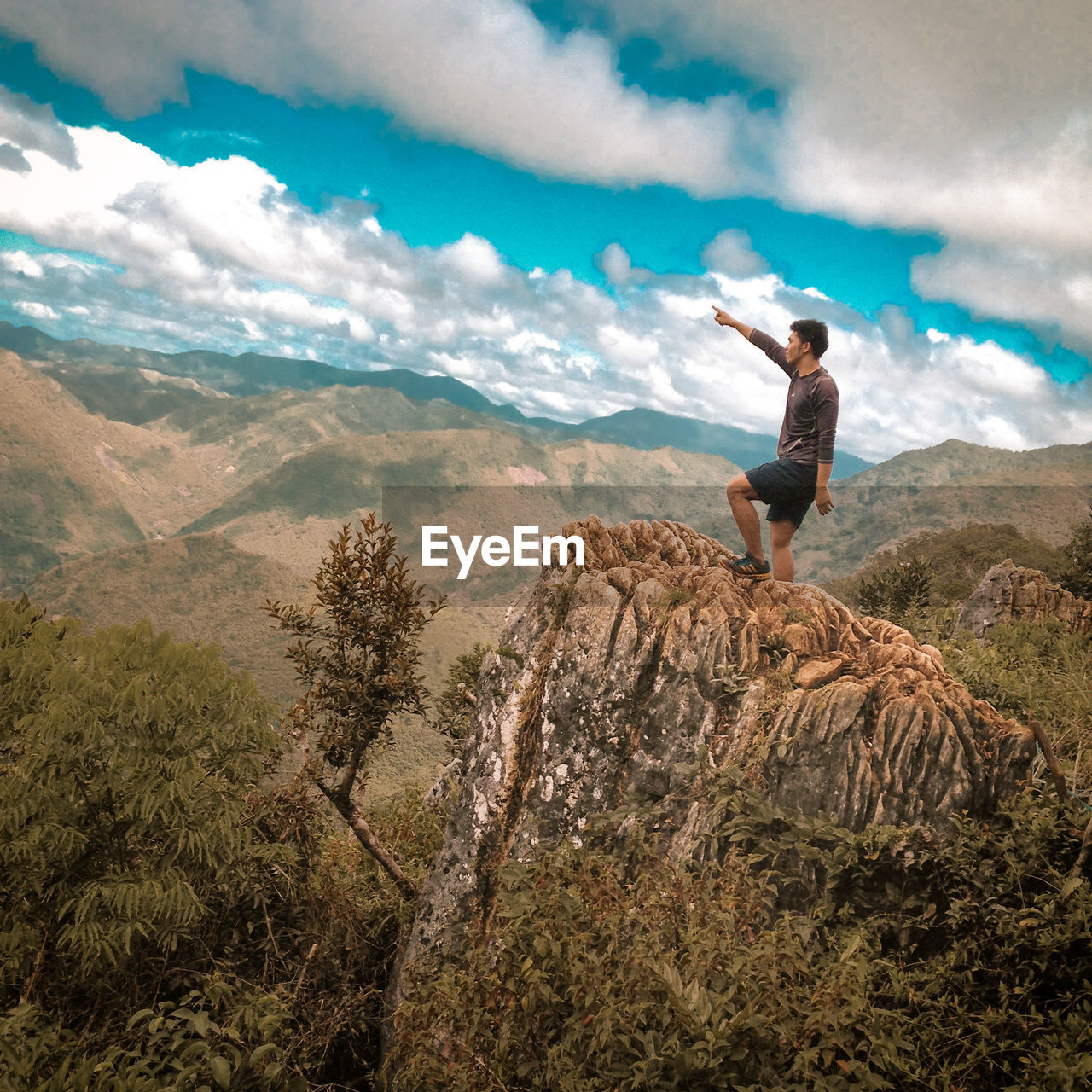 Full length of man standing on rock against sky