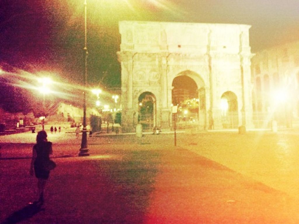 WOMAN STANDING IN ILLUMINATED TUNNEL